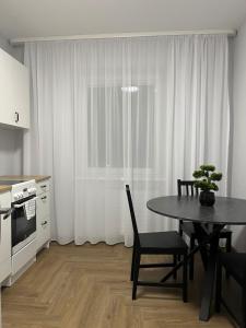 a kitchen with a table and chairs and a window at Kerulis Apartments in Vilnius