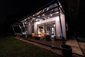 a lit up house with a deck at night at La Danta Lodge - Rio Celeste in Bijagua +3 photos