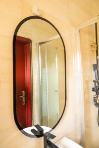 a bathroom mirror with a red door and a sink at Ashtead Haven in Ikate +54 photos