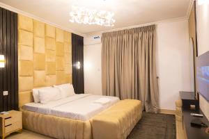 a hotel room with a bed and a television at Ashtead Haven in Ikate