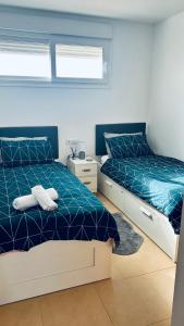 two beds in a bedroom with blue and white at Casa Carlitos Las Terrazas de La Torre Golf Resort in Murcia +51 photos