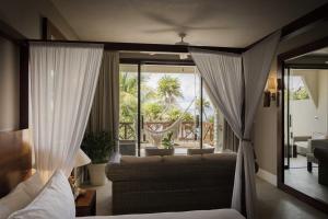 a living room with a couch and a large window at Beachfront Bliss Suite in Balcheil