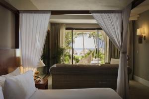 a bedroom with a bed and a window with a view at Beachfront Bliss Suite in Balcheil