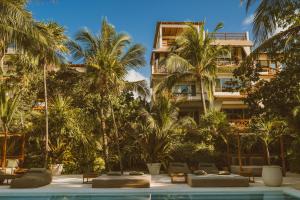 a hotel with palm trees and a swimming pool at Beachfront Bliss Suite in Balcheil