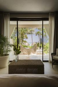 a living room with a hammock and a bedroom at Beachfront Bliss Suite in Balcheil +128 photos