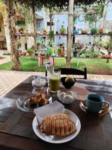 a table with a plate of bread and a glass of orange juice at Suíte Família 5 pessoas - Queen's Hotel in Formosa +67 photos