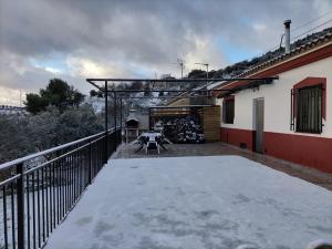 a balcony of a house with snow on the ground at El Almendro de Fuentes Nuevas in Castril