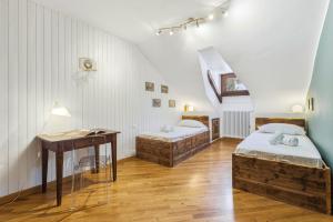 a room with two beds and a desk and a table at Hostdomus - Inside Alps Suite in Cesana Torinese