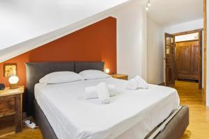 a bedroom with a large bed with white sheets at Hostdomus - Inside Alps Suite in Cesana Torinese