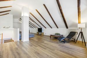 an attic living room with wooden floors and exposed beams at Hostdomus - Inside Alps Suite in Cesana Torinese +18 photos