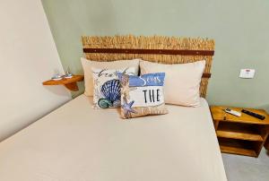a bed with pillows and a sign that says you save at Casas Costa Dos Corais - 200m do mar, Climatizada, Confortável e Completa in Japaratinga