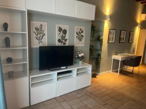 a living room with a television on a white entertainment center at Navigli Darsena - Luxury Apartment with balcony in Milan