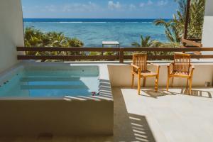 two chairs and a table with a view of the ocean at Sunset Crown Suite in Balcheil