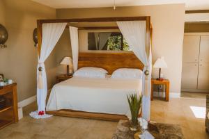 a bedroom with a white bed with a canopy at Sunset Crown Suite in Balcheil