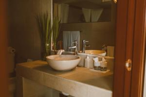 a bathroom with a bowl sink and a mirror at Sunset Crown Suite in Balcheil