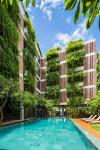 a swimming pool in front of some tall buildings at Mulberry Collection Silk Eco in Hoi An