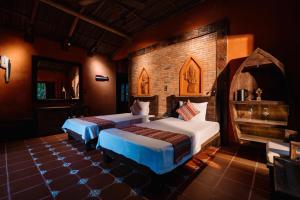 a bedroom with two beds and a brick wall at Whale Island Resort in Dam Mon +138 photos