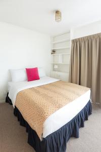 a bedroom with a large bed with a red pillow at Boxed Bliss on Fox in Hamilton