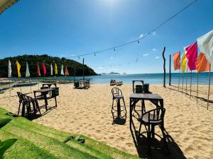 a group of tables and chairs on a sandy beach at Dandal Bay view in El Nido