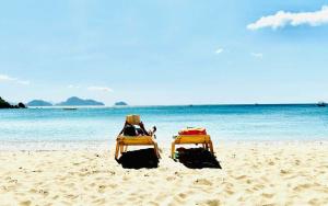 two beach chairs sitting on the sand on the beach at Dandal Bay view in El Nido