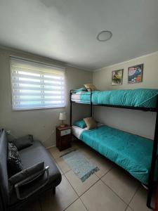 a room with two bunk beds and a couch at Mels House Batuco in El Cerrillo