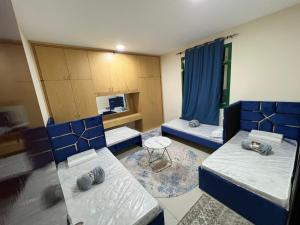 a room with two beds and a table at ALEX Hostel - Bed in a shared room - C504 in Sharjah