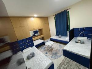a room with two beds and a table at ALEX Hostel - Bed in a shared room - C504 in Sharjah