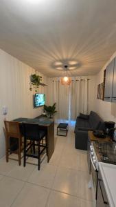 a kitchen and living room with a table and a couch at Praia e Cambirela in Palhoça