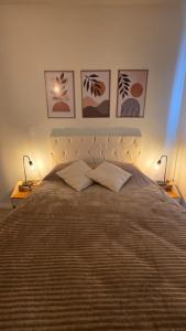 a bedroom with a large bed with three pictures on the wall at Praia e Cambirela in Palhoça +10 photos