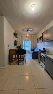 a kitchen and living room with a couch and a table at Praia e Cambirela in Palhoça