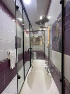 a bathroom with a large tub with a glass shower at Pyramids Sunshine Hotel in Cairo +70 photos