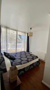a bedroom with a bed and a large window at Borde Costero in Valparaíso