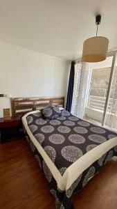 a bedroom with a bed in a room with a window at Borde Costero in Valparaíso