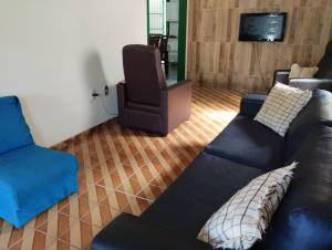 a living room with a couch and a chair at Casa Branca in Vila Velha