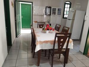a kitchen with a table and chairs and a green door at Casa Branca in Vila Velha