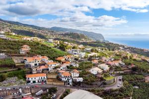 an aerial view of a town on a hill with the ocean at Sol Blessing by GALMI in Ponta do Sol