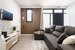 a living room with a couch and a tv at Sol Blessing by GALMI in Ponta do Sol
