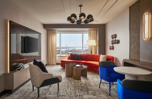 a living room with a red couch and blue chairs at MGM Grand Detroit in Detroit