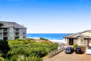 a house with two cars parked in front of the beach at Neptune's Trident in Lincoln Beach