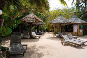 a group of lounge chairs and umbrellas on a beach at Whale Island Resort in Dam Mon