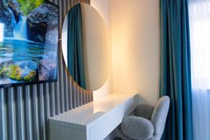 a mirror on a wall next to two chairs at Hotel Tommy in Budva