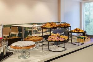 a buffet with different types of bread and pastries at B&B HOTEL Como Baradello in Como