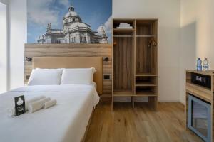 a bedroom with a bed and a building on the wall at B&B HOTEL Como Baradello in Como