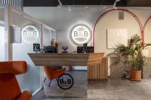 an office with a reception desk and two mirrors at B&B HOTEL Como Baradello in Como +30 photos