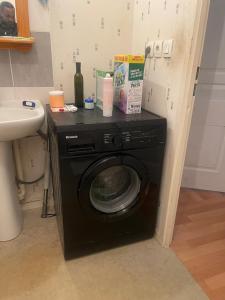 a black washing machine in a bathroom next to a sink at Lux 3 in Orléans