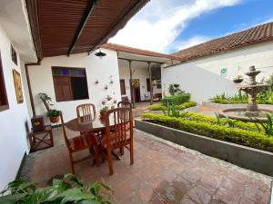 a patio with a table and chairs and a fountain at Hotel Casa Antigua Buga in Buga