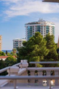 a tall building with a tree in front of it at Hotel Tommy in Budva