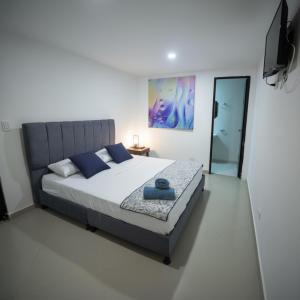 a bedroom with a large bed with blue pillows at Open Sea Hotel Cartagena - Frente al mar in Cartagena de Indias +53 photos