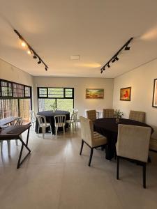 a dining room with tables and chairs and windows at Pousada Cobogó - MotoWeek, ANP in Brasília