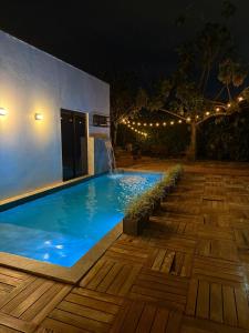 a swimming pool with a waterfall in a backyard at night at Pousada Cobogó - MotoWeek, ANP in Brasília